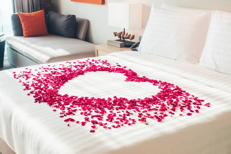 Valentýn v ložnici lupeny růží na posteli