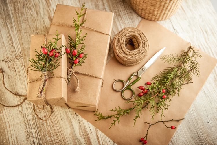 Vánoční dárky zabalené do obyčejného papíru a ozdobené haluzemi šipky