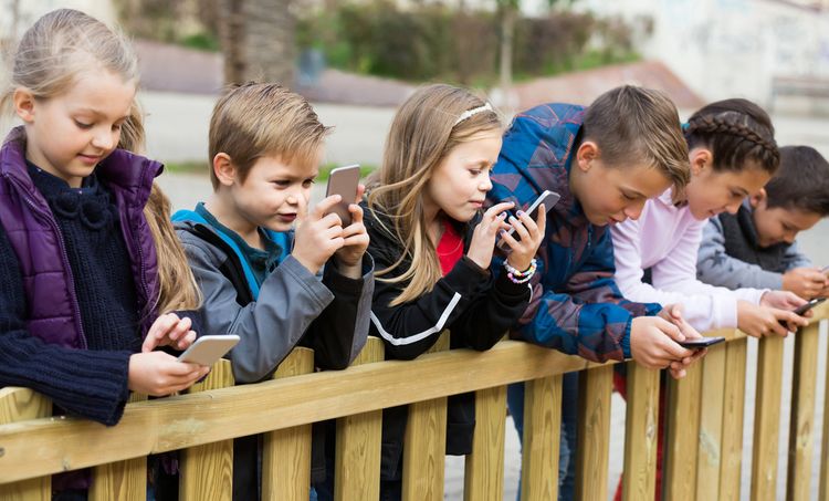 Děti hrající si s mobilními telefony