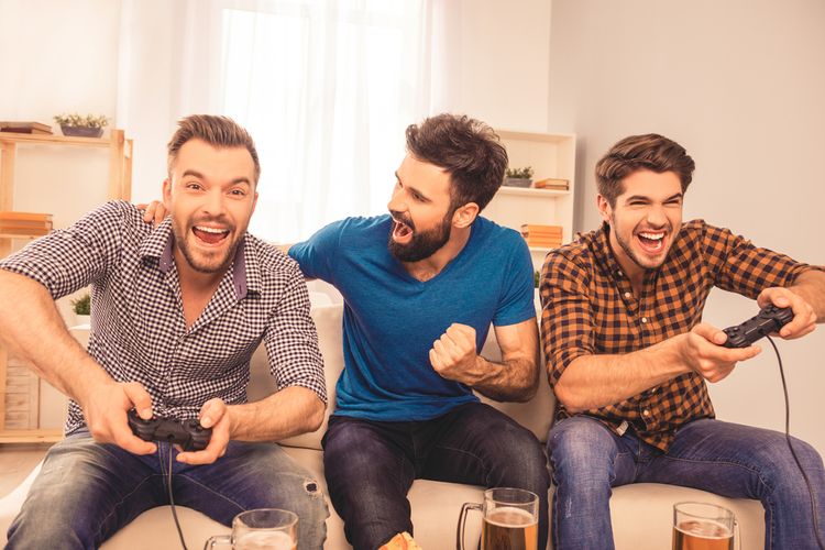 Muži hrající hry na televizoru a pijící pivo