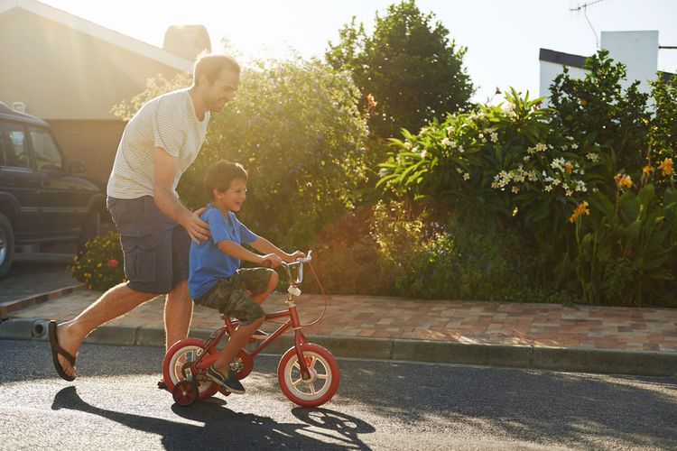 Otec učící syna jezdit na kole