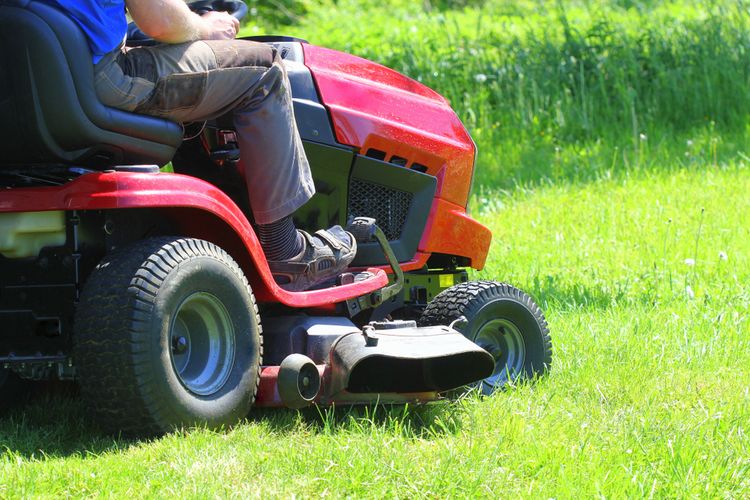 Červený zahradní traktor na sekání trávy