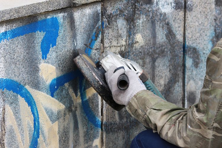 Odstraňování grafitů ze zdi pomocí brusky